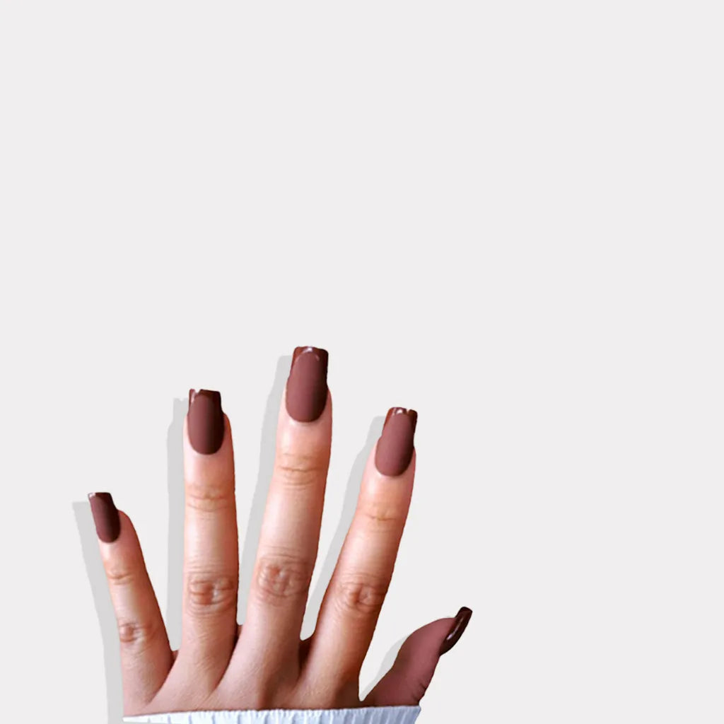Fingers up pose showing de blinkie Cocoa Suede rich chestnut velvet matte press-on nails in medium square shape against grey background with white ribbed knit sleeve